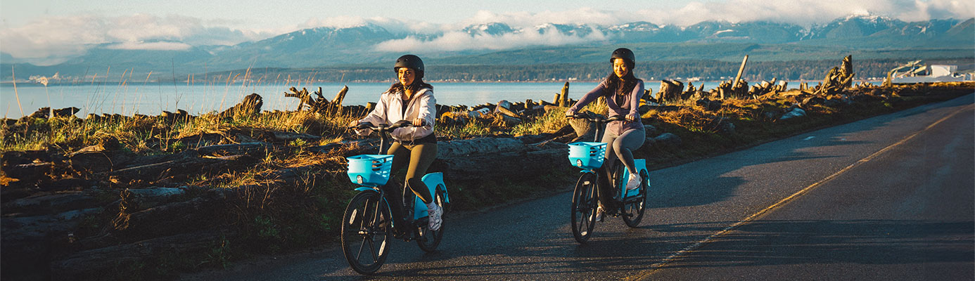 Women biking Evolve bikes on a scenic road