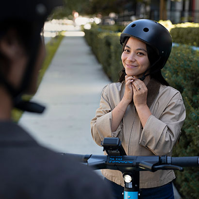 Woman putting on an Evolve helmet before riding her bike
