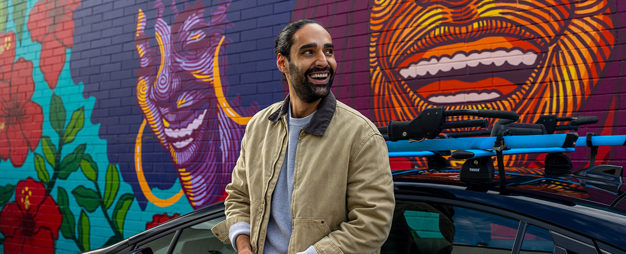 Man standing in front of a mural wall with an Evo Car Share