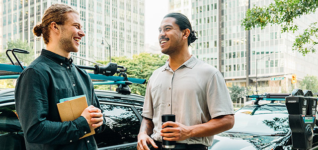 Two men talking in front of parked Evos in a city